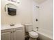 Bright bathroom features a white vanity, round mirror, and combined shower and tub with white tile surround at 3312 Victory Palm Dr, Edgewater, FL 32141