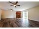 Spacious living room features a decorative wood fireplace, two ceiling fans, and wood flooring at 3312 Victory Palm Dr, Edgewater, FL 32141