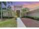 Beautiful home exterior with lush landscaping, palm trees, and inviting front entry at sunset at 336 Highcroft Ct, Lake Mary, FL 32746