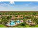 Aerial view showcasing a community's central amenities, featuring a pool, playground, and clubhouse surrounded by lush greenery at 3640 Sail Harbor Dr, Kissimmee, FL 34746