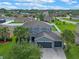 Aerial view of a landscaped two-story home with a three-car garage in a lovely neighborhood at 3640 Sail Harbor Dr, Kissimmee, FL 34746