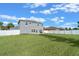 Expansive backyard with green grass, white fencing, and a gray two-story house providing ample outdoor space at 3640 Sail Harbor Dr, Kissimmee, FL 34746