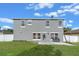 Spacious backyard with a gray two-story home, green lawn, patio area, and white fencing for privacy at 3640 Sail Harbor Dr, Kissimmee, FL 34746