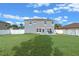 Large backyard featuring a well-maintained lawn, white fencing, and a modern gray house for outdoor enjoyment at 3640 Sail Harbor Dr, Kissimmee, FL 34746