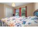 Bright bedroom with a floral bedspread, two windows with blinds and curtains, and a closet with white doors at 3640 Sail Harbor Dr, Kissimmee, FL 34746