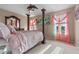 Bright bedroom with a four-poster bed, ceiling fan, and two windows with stylish pink curtains at 3640 Sail Harbor Dr, Kissimmee, FL 34746