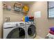 Functional laundry room with a Samsung washer and dryer, overhead shelving, and ample storage space at 3640 Sail Harbor Dr, Kissimmee, FL 34746