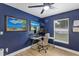 Cozy office with blue accent wall, a modern desk, and natural light from the window at 3706 Andover Cay Blvd, Orlando, FL 32825