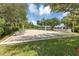 Sand volleyball court surrounded by a lush lawn and mature trees on a sunny day at 3706 Andover Cay Blvd, Orlando, FL 32825