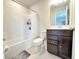 Well-maintained bathroom with tub and shower combo, featuring a modern dark vanity and light tile floor at 3823 Spruce Creek Dr, Lakeland, FL 33811
