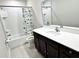 Bathroom with dark wood cabinets, white countertop, and shower with patterned curtain at 3823 Spruce Creek Dr, Lakeland, FL 33811