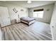 Comfortable bedroom featuring wood-look floors, neutral walls, and a bright window at 3823 Spruce Creek Dr, Lakeland, FL 33811