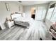 Bedroom with light hardwood flooring, white furniture, and a view into the bathroom at 3823 Spruce Creek Dr, Lakeland, FL 33811