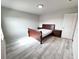 Bright bedroom with a queen bed frame, side tables, and light hardwood style flooring at 3823 Spruce Creek Dr, Lakeland, FL 33811