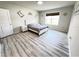 Comfortable bedroom featuring wood-look floors, neutral walls, and a bright window at 3823 Spruce Creek Dr, Lakeland, FL 33811