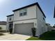 Two-story home featuring a gray two-car garage, manicured lawn, and tasteful landscaping at 3823 Spruce Creek Dr, Lakeland, FL 33811