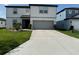 Charming two-story home featuring a paved driveway, a two-car garage, and lush green landscaping at 3823 Spruce Creek Dr, Lakeland, FL 33811