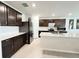 Open-concept kitchen with a large island, stainless appliances, and dark wood cabinets at 3823 Spruce Creek Dr, Lakeland, FL 33811