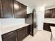 Modern kitchen with dark wood cabinets, quartz countertops, and stainless steel refrigerator at 3823 Spruce Creek Dr, Lakeland, FL 33811