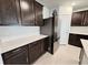 Kitchen featuring sleek stainless steel appliances, dark cabinetry, and white quartz counters at 3823 Spruce Creek Dr, Lakeland, FL 33811
