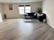 Open-concept living room with hardwood flooring, black sofas, and bright natural light at 3823 Spruce Creek Dr, Lakeland, FL 33811