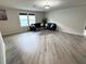 Spacious living room with hardwood flooring, black sofas, and natural light at 3823 Spruce Creek Dr, Lakeland, FL 33811
