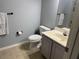 Standard bathroom with a toilet, vanity, and mirror featuring neutral walls at 4011 Venetian Bay Village # 104, Kissimmee, FL 34741
