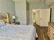 Bedroom featuring a bed, nightstand with lamp, hardwood floors and an open door to the bathroom at 4011 Venetian Bay Village # 104, Kissimmee, FL 34741