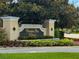 An ornate stone sign for Venetian Bay Villages, surrounded by manicured landscaping at 4011 Venetian Bay Village # 104, Kissimmee, FL 34741