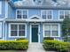 Charming two-story condo featuring a green front door, white trim, and manicured landscaping at 4011 Venetian Bay Village # 104, Kissimmee, FL 34741