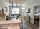 An open living area with modern lighting, comfortable seating, and an adjacent bedroom at 4011 Venetian Bay Village # 104, Kissimmee, FL 34741