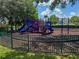 Fenced playground featuring colorful slides, climbing structures, and a soft landing surface at 4011 Venetian Bay Village # 104, Kissimmee, FL 34741