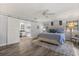 Bright primary bedroom with a king bed, hardwood floors, and bathroom access through sliding barn door at 548 Timber Ridge Dr, Longwood, FL 32779