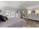 Bright primary bedroom features hardwood floors and view into kitchen; TV mounted above dresser at 548 Timber Ridge Dr, Longwood, FL 32779