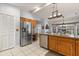 Kitchen with stainless steel refrigerator, wooden cabinets, tiled floors, and adjacent eating area at 548 Timber Ridge Dr, Longwood, FL 32779