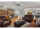 Spacious living room featuring a brick fireplace, leather furniture, and hardwood floors at 548 Timber Ridge Dr, Longwood, FL 32779