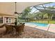 Covered outdoor patio features a table and chairs beside a screened-in pool, perfect for entertaining at 548 Timber Ridge Dr, Longwood, FL 32779
