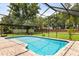 Enjoy a refreshing swim in the screened-in pool surrounded by lush greenery and a brick-paved patio at 548 Timber Ridge Dr, Longwood, FL 32779
