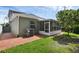 Exterior view of the screened patio, home's siding, and brick-paved backyard at 5852 Mariposa Cove Ln, Orlando, FL 32822