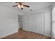 Bedroom featuring wood-look laminate flooring, closet, ceiling fan and an open entry at 5852 Mariposa Cove Ln, Orlando, FL 32822