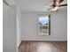 Well-lit bedroom with wood-look laminate flooring, ceiling fan, and large window at 5852 Mariposa Cove Ln, Orlando, FL 32822
