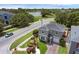 Aerial view of the property showcasing landscaping, a two-car garage, and mature trees at 5852 Mariposa Cove Ln, Orlando, FL 32822