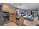 Modern kitchen with wood cabinets, stainless steel appliances, and an open view to the living room at 5852 Mariposa Cove Ln, Orlando, FL 32822