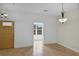 Open living area featuring tile floors, neutral walls, and a doorway with natural light at 5852 Mariposa Cove Ln, Orlando, FL 32822
