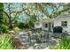 Spacious backyard with a patio area, dining set, and mature trees providing shade and privacy at 610 Kittredge Dr, Orlando, FL 32805