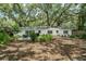 Expansive backyard with mature trees, lush greenery, and a patio area perfect for outdoor gatherings at 610 Kittredge Dr, Orlando, FL 32805