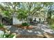 Landscaped backyard with patio, dining set, and mature trees creating a peaceful outdoor space at 610 Kittredge Dr, Orlando, FL 32805