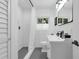 Bright bathroom with a shower, modern black fixtures, white tile, and a window providing natural light at 610 Kittredge Dr, Orlando, FL 32805