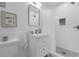 All-white bathroom featuring tiled floors, tiled walls, vanity, mirror, and shower at 610 Kittredge Dr, Orlando, FL 32805