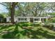 Charming single-story home featuring a well-manicured lawn and a welcoming facade with mature trees in front at 610 Kittredge Dr, Orlando, FL 32805